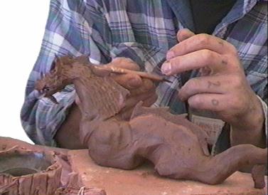 Person making dragon from clay