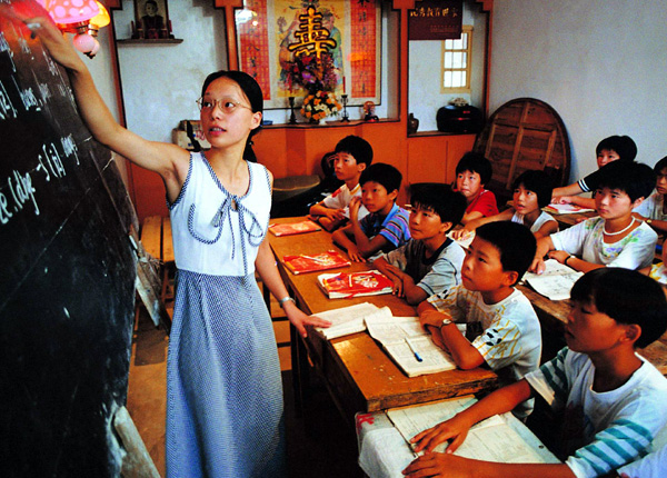 School teachers tutoring children free from any charge in a fishing village in coastal area in southeast China.